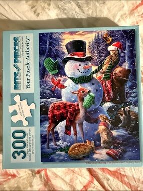 Bits and Pieces 300pc Holiday Puzzle Who’s Decorating the Snowman?By Larry Jones